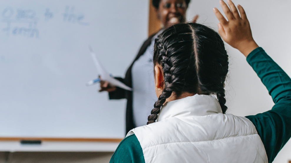 A young person going back to school raising their hand