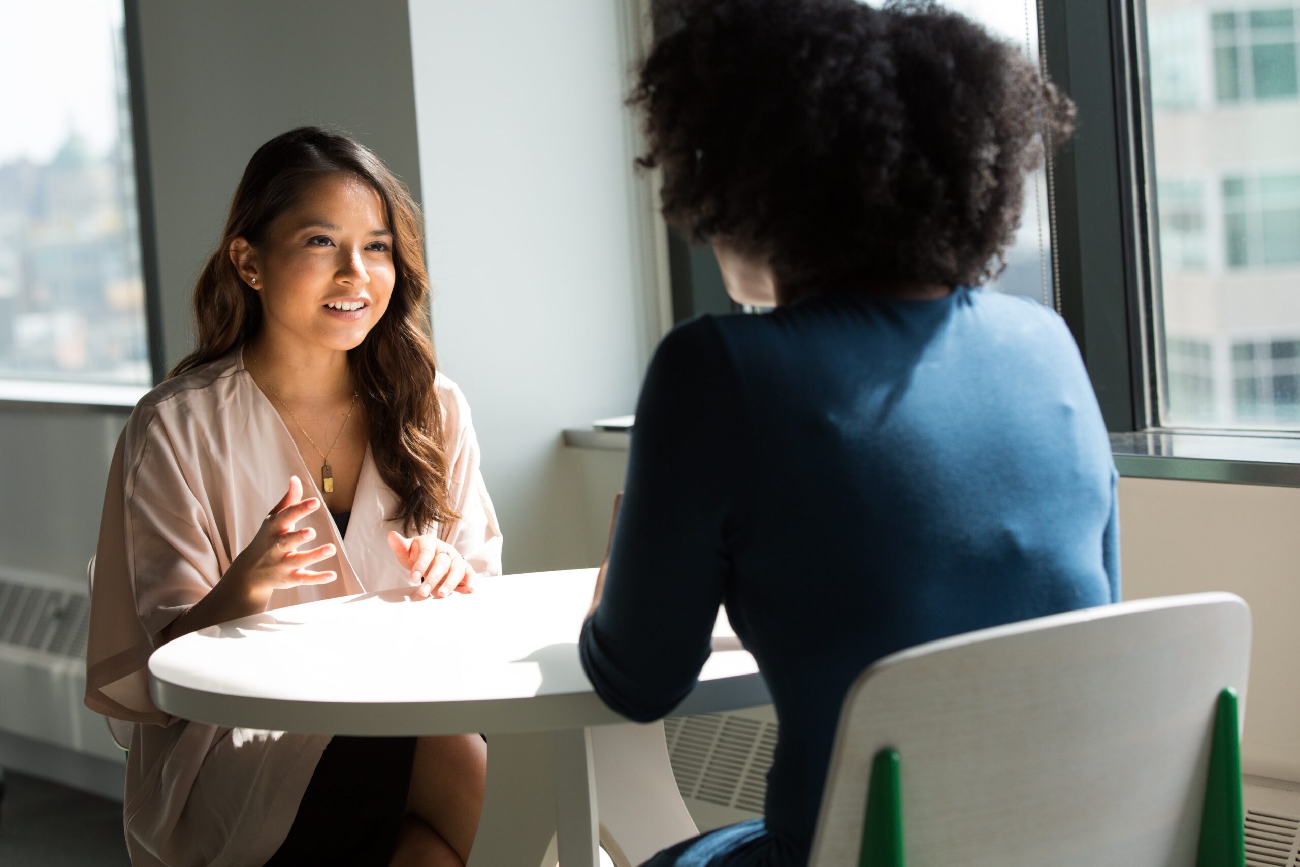 Two young people sitting on chairs talking to each other about careers