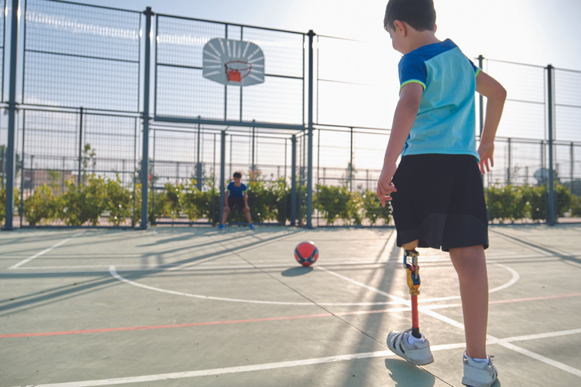 An image of a young person playing outside on a basketball court for Kids Help Phone’s 2023–2027 IDEA Strategy and Action Plan