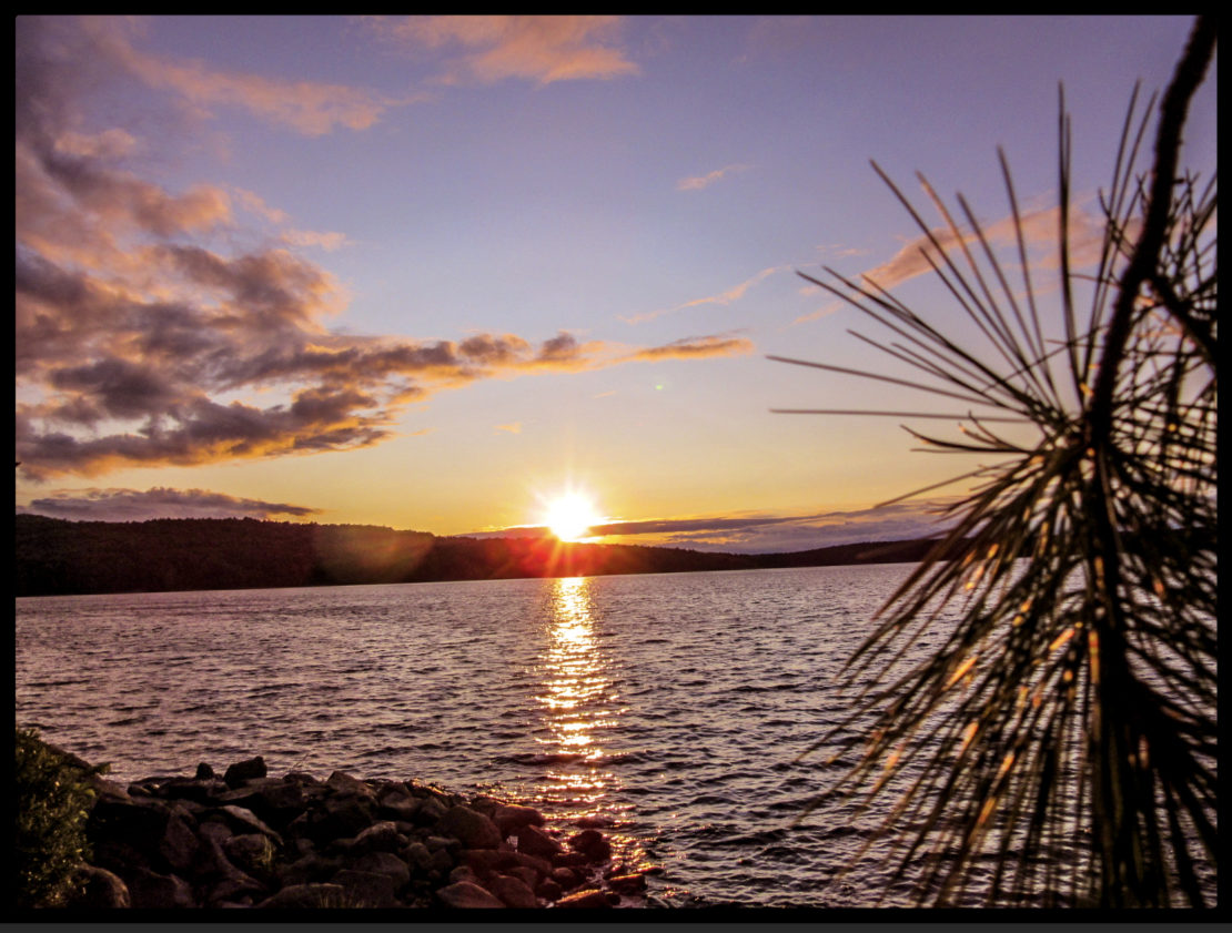 A photograph of a lake scene at sunset