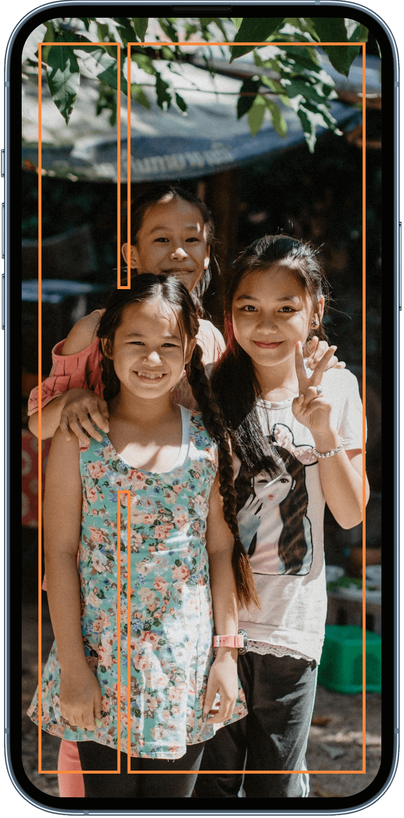 A portrait-oriented cell phone framed image of a group of Indigenous youth posing in front of the camera.