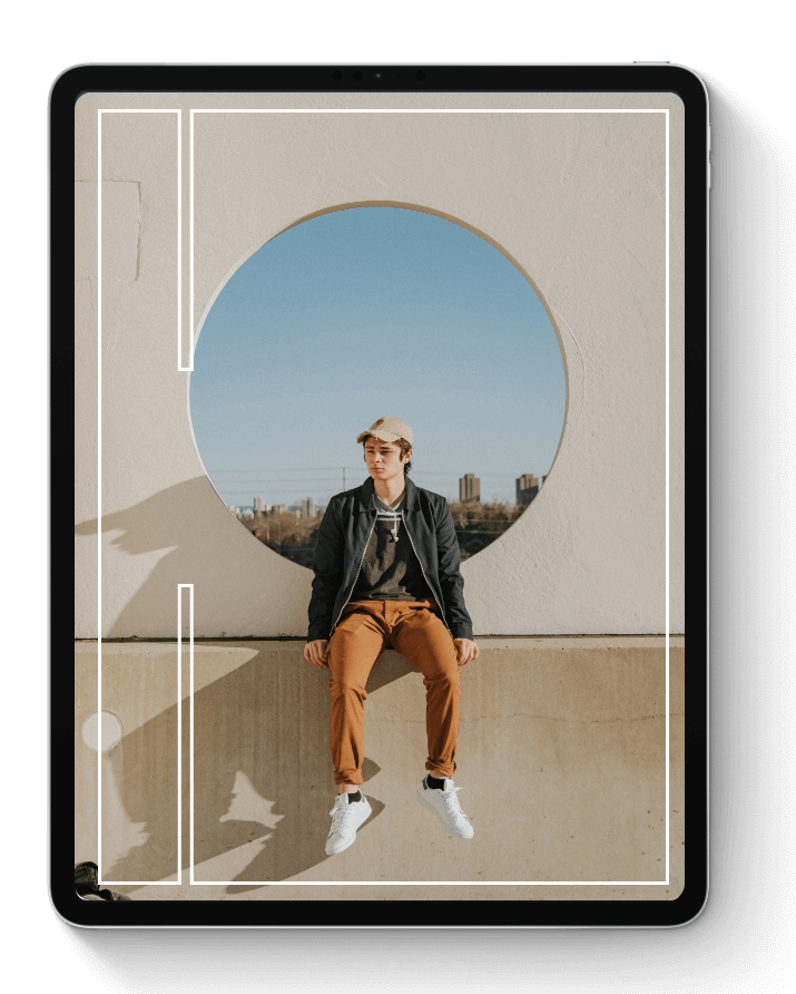 A male youth sitting on a concrete block looking forward.