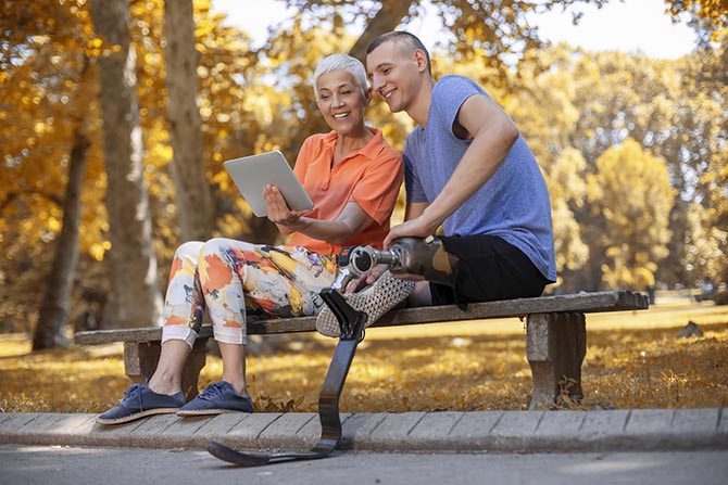 Young person and an adult sitting on a bench outside